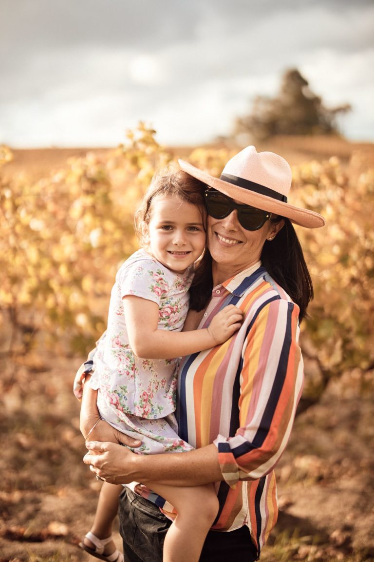 A mother and daughter hug and smile in a vineyard to show happy times along The South West Edge road trip