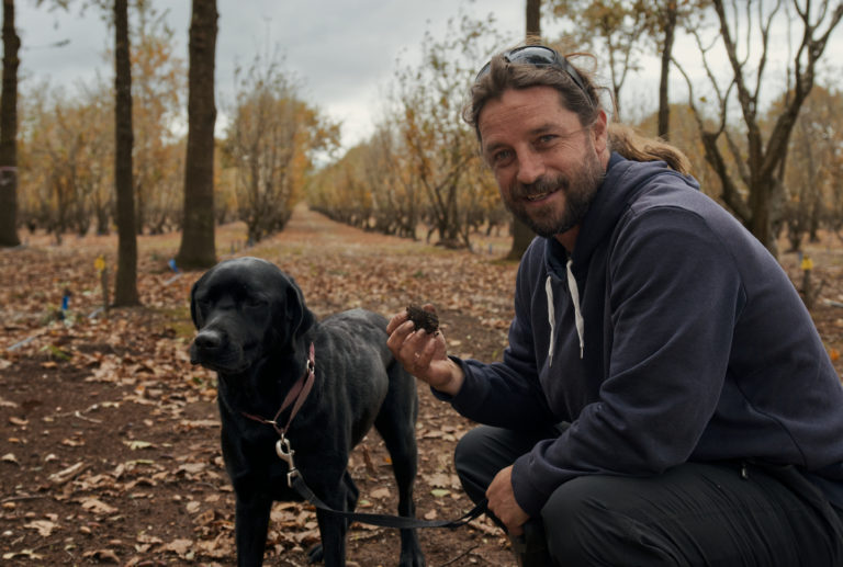 A portrait image of a man with a dog hunting for truffles in Manjimup to show the unique local characters and gourmet food en route along The Edge