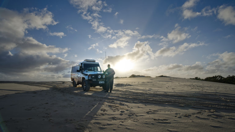A landscape image of a four wheel drive at sand dunes to show natural phenomena and local characters on The South West Edge road trip