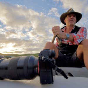 A landscape image of Sean Blocksidge canoeing on the Margaret River with a camera to show the local characters of The South West Edge road trip