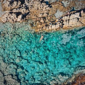 A drone image shows a cyrstal clear pristine rock pool found on the south western australia road trip