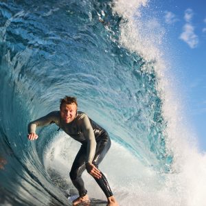 A man surfs a perfect wave in Margaret River to show this adventurous activity on this south west australia road trip