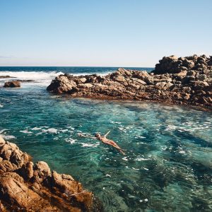 A woman floats in a pristine crystal clear rock pool near Yallingup to show nature based attractions on The South West Edge road trip