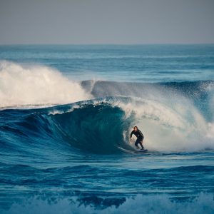 A surfer rides a big wave in Margaret River to show adventure activities on The South West Edge road trip