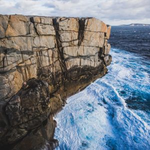 Image to depict the view from The Gap and Natural Bridge viewing platform in Albany. Shows rocky cliff and blue surging Southern Ocean