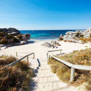 A landscape image of a sandy staircase down to a pristine cove beach on Rottnest Island to show the beaches en route along The South West Edge