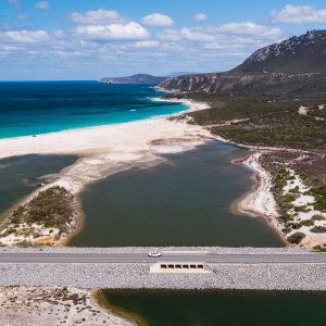car drives over bridge with ocean and river to show landscape in Fitzgerald River National Park